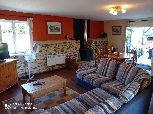 Downstairs lounge with smart TV, Wood Stove  and sofa bed. Doors open to BBQ and Patio area